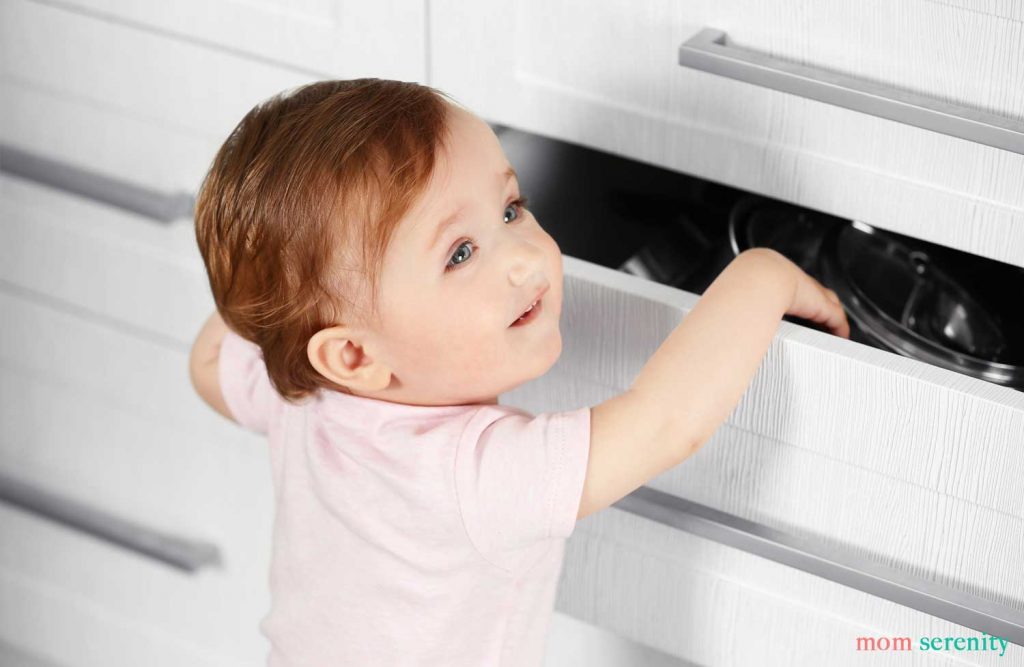 Baby reaching into drawer that isn't baby proofed